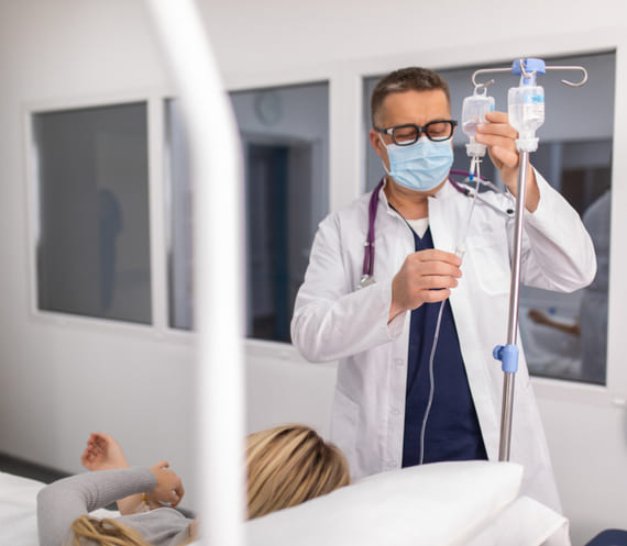 Врач в клинике устанавливает капельницу пациентке